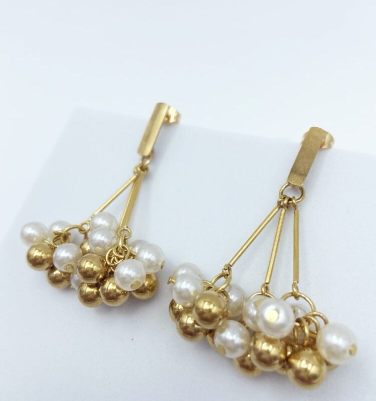 Beautiful dangling earrings with delicate soft and gold colored pearls, made of stainless steel.